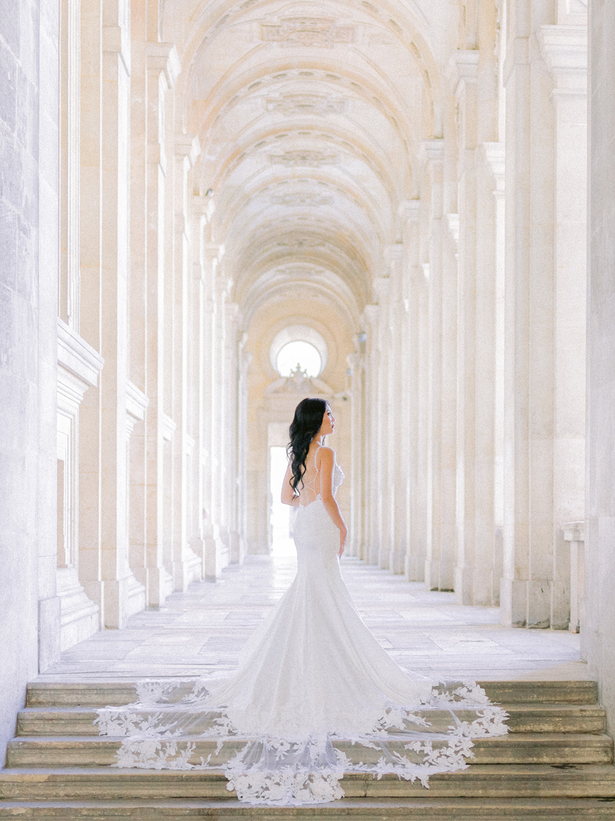Bride posing on the stairs of the Louvre Museum